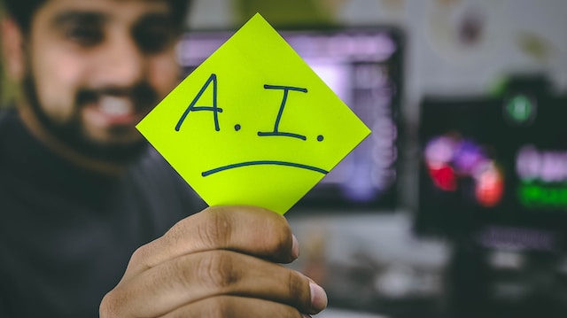 man holding up post-it note that reads 'A.I.'